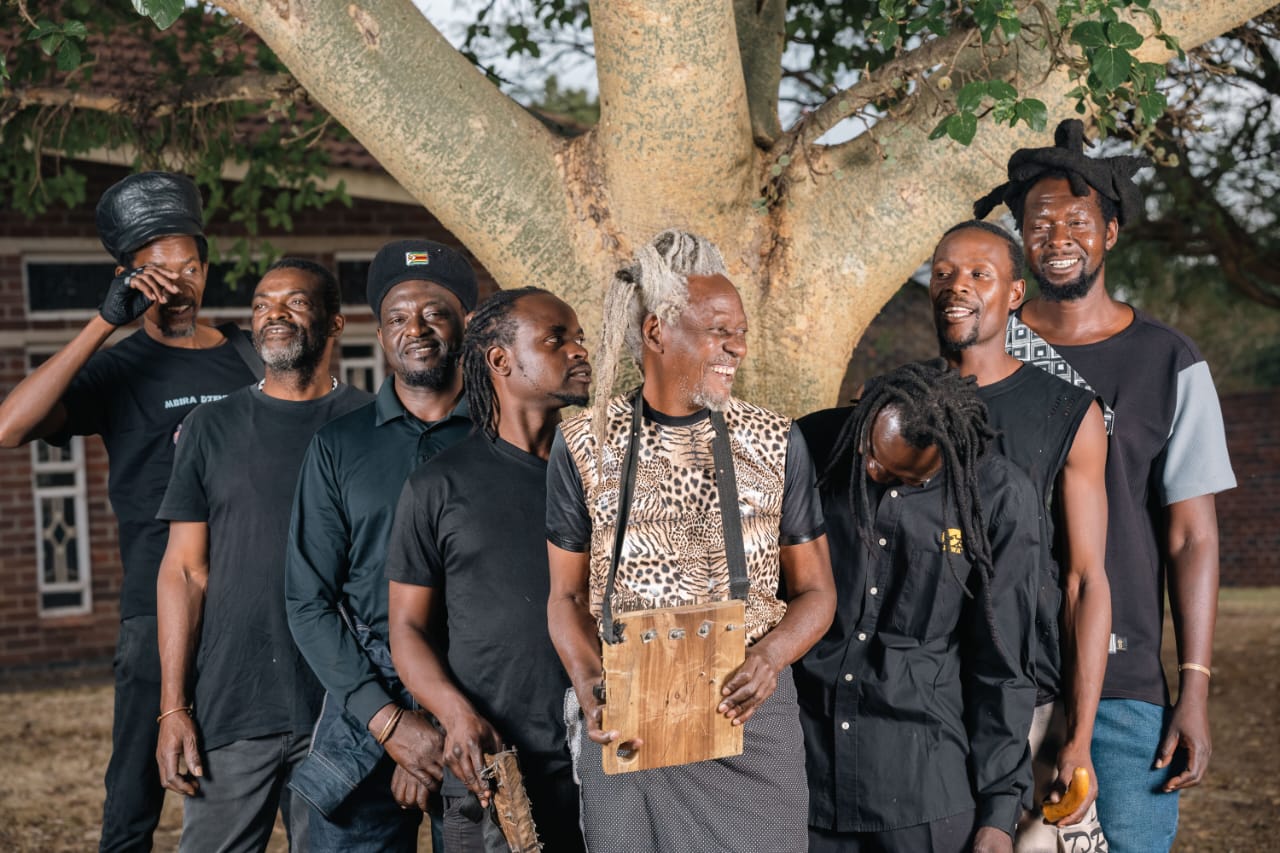 Mbira Dzenharira with their mbira beneath a tree